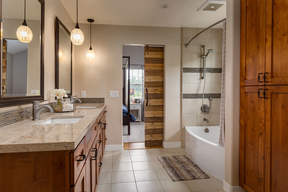 Design ideas for a large country master bathroom in Other with shaker cabinets, medium wood cabinets, an alcove shower, beige tile, porcelain tile, beige walls, porcelain floors, a wall-mount sink, solid surface benchtops, beige floor and a shower curtain.