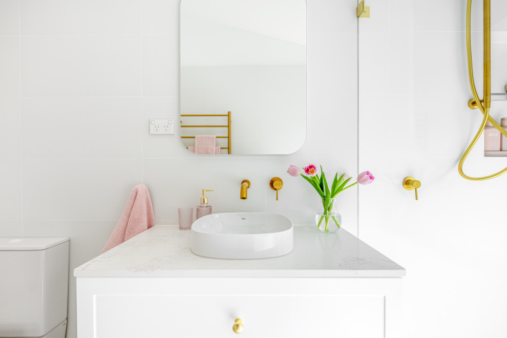 This is an example of a medium sized modern family bathroom in Sydney with shaker cabinets, white cabinets, a walk-in shower, a two-piece toilet, pink tiles, mosaic tiles, white walls, porcelain flooring, a vessel sink, grey floors, an open shower, white worktops, a wall niche, a single sink and a freestanding vanity unit.