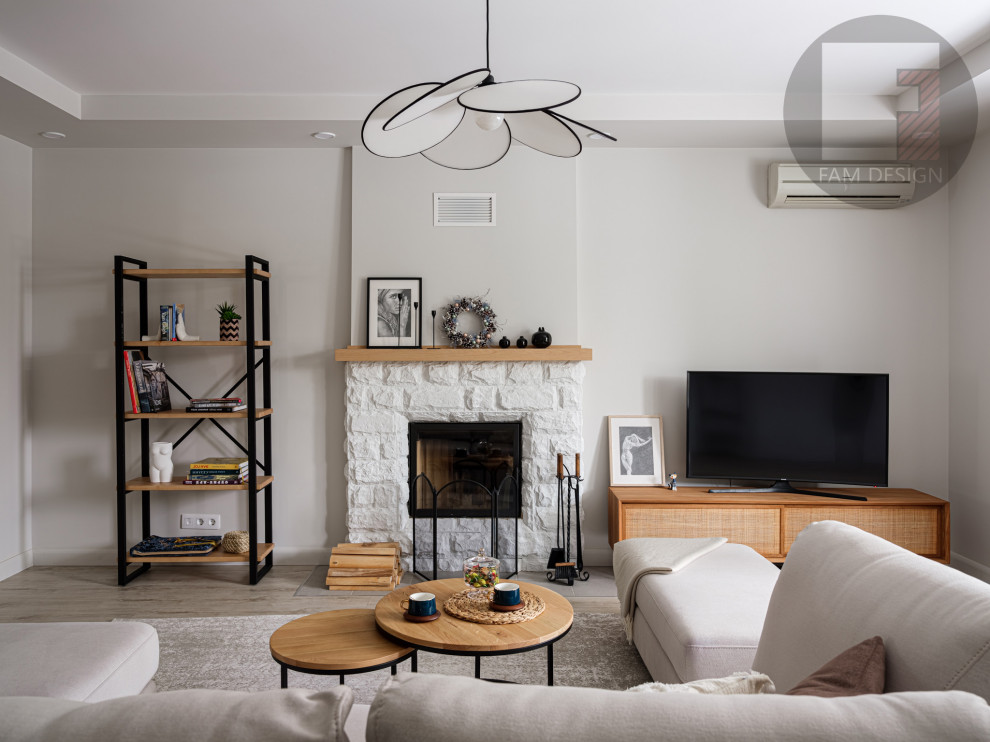 This is an example of a large scandinavian living room in Moscow with grey walls, laminate floors, a standard fireplace, a brick fireplace surround, a freestanding tv and grey floors.