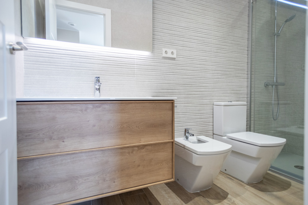 Bathroom - mid-sized mediterranean master beige tile and ceramic tile ceramic tile, brown floor and single-sink bathroom idea in Barcelona with flat-panel cabinets, medium tone wood cabinets, a two-piece toilet, a trough sink, white countertops and a floating vanity