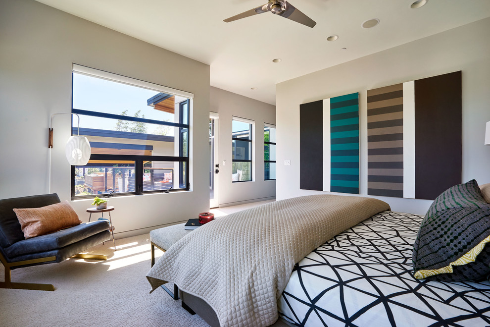 Photo of a large contemporary master bedroom in Portland with white walls and carpet.