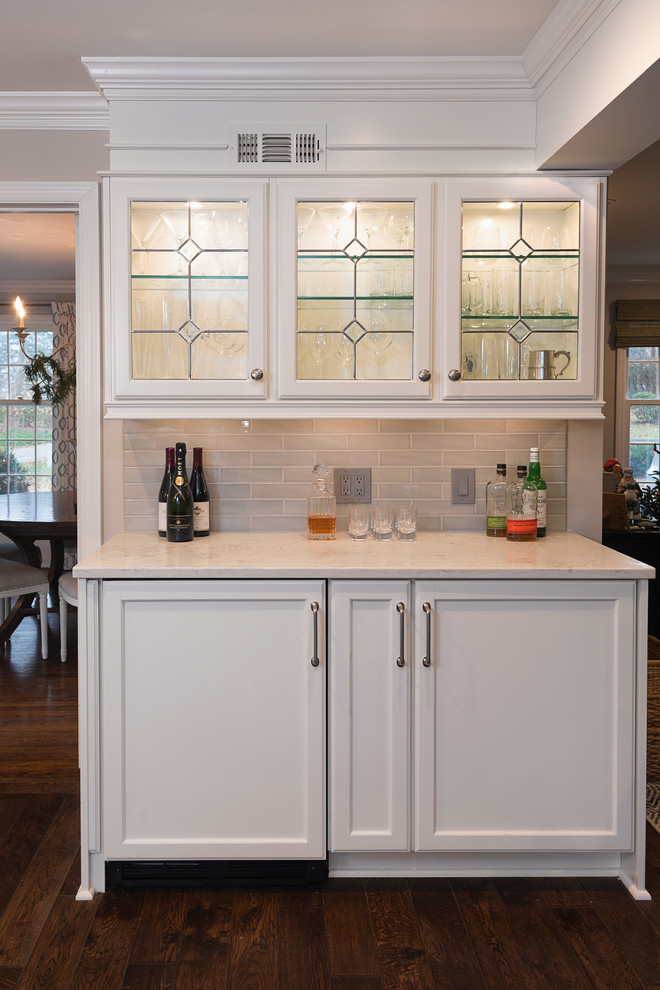 Open concept kitchen - huge transitional l-shaped medium tone wood floor open concept kitchen idea with flat-panel cabinets, white cabinets, marble countertops, gray backsplash, porcelain backsplash, paneled appliances and an island