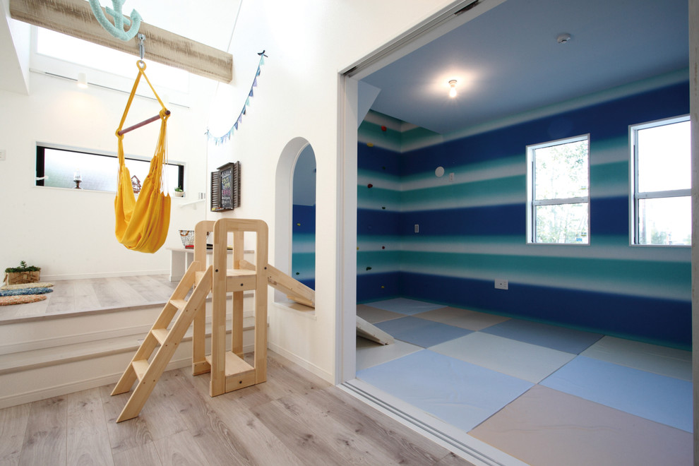 This is an example of a country gender-neutral kids' playroom for kids 4-10 years old in Other with multi-coloured walls, plywood floors and beige floor.