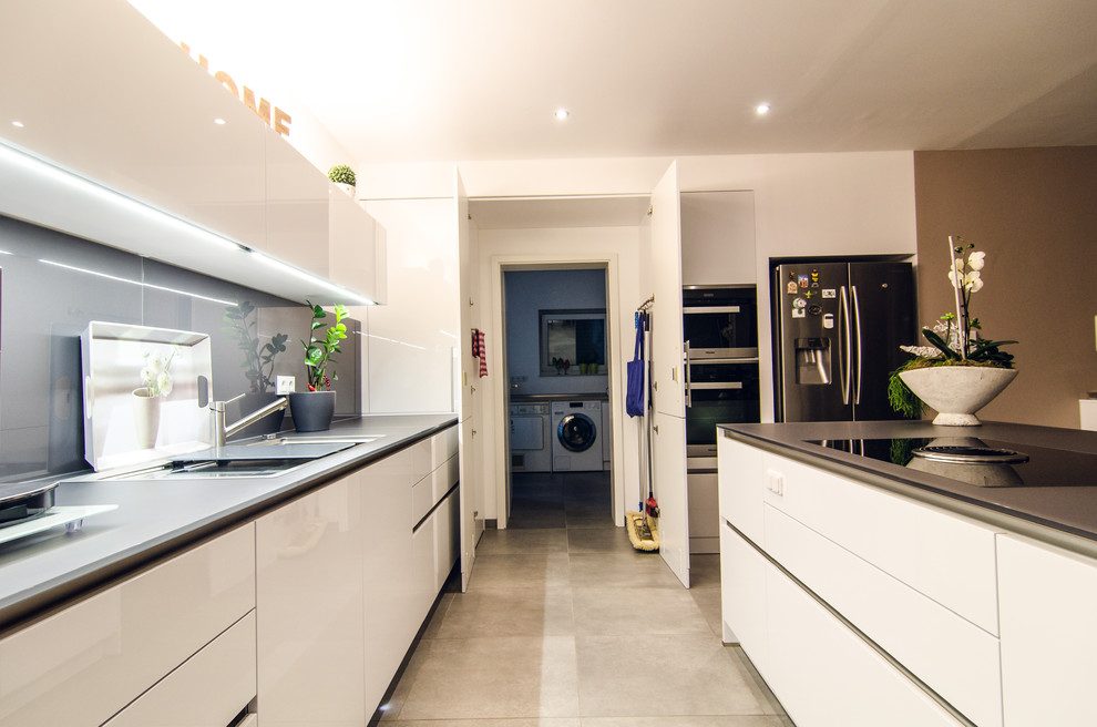 Offene Moderne Küche in L-Form mit weißen Schränken und Kücheninsel in Frankfurt am Main