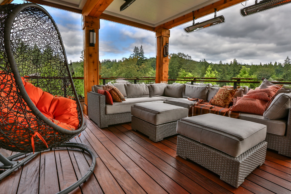 Deck - large modern backyard deck idea in Seattle with a roof extension