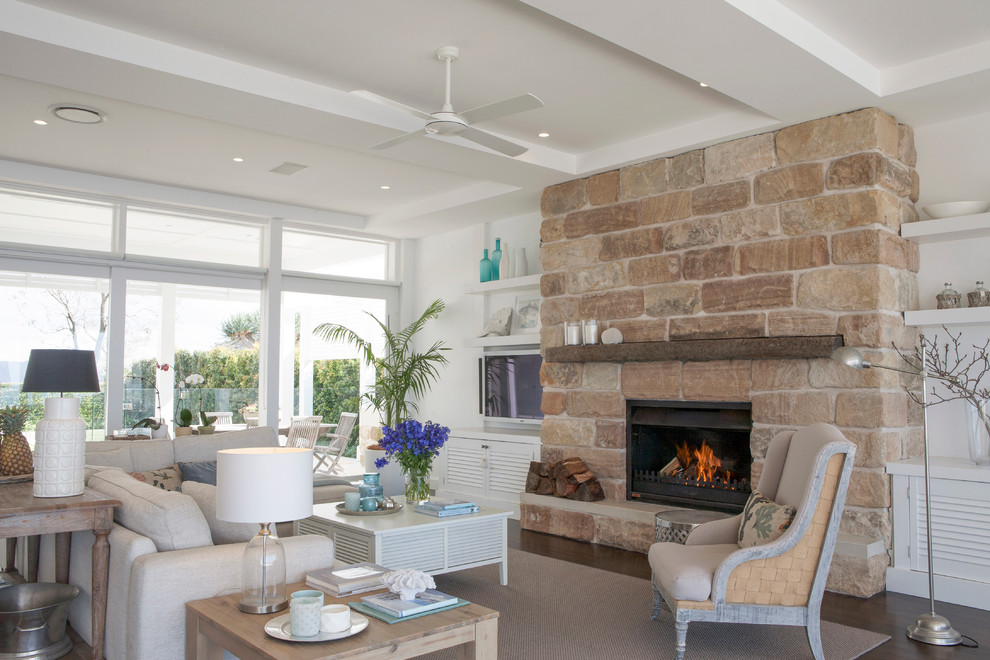 Design ideas for a large beach style open concept living room in Sydney with white walls, dark hardwood floors, a standard fireplace, a stone fireplace surround and a wall-mounted tv.