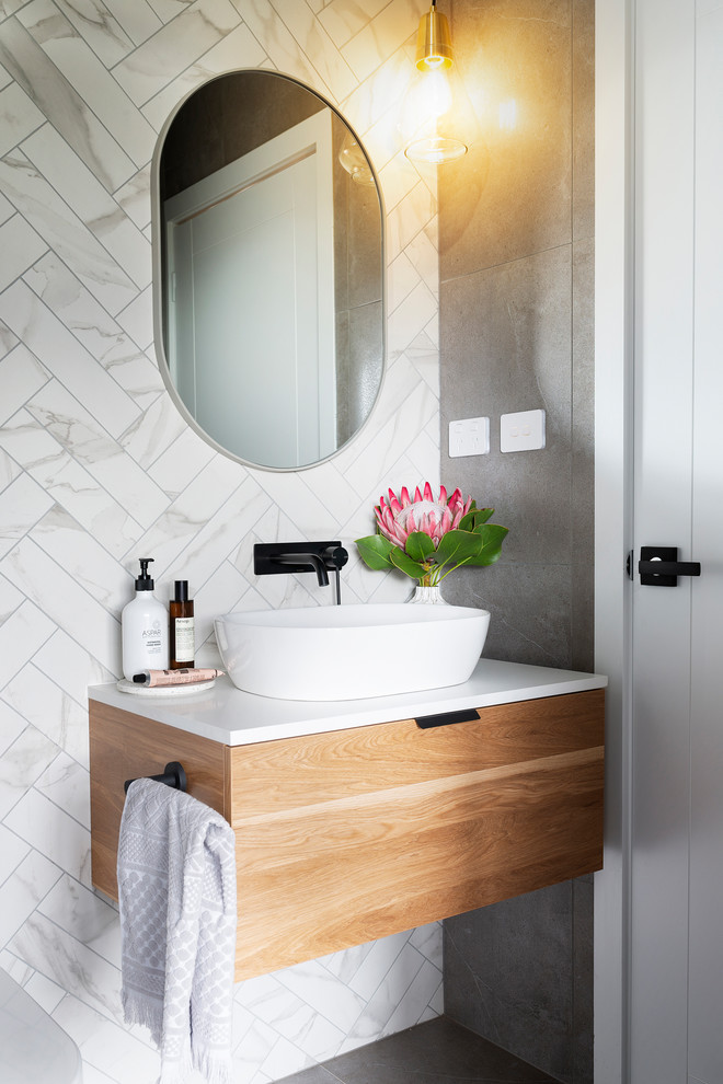 Design ideas for a small modern powder room in Canberra - Queanbeyan with medium wood cabinets, a one-piece toilet, black and white tile, porcelain tile, white walls, porcelain floors, a vessel sink, engineered quartz benchtops, grey floor and white benchtops.