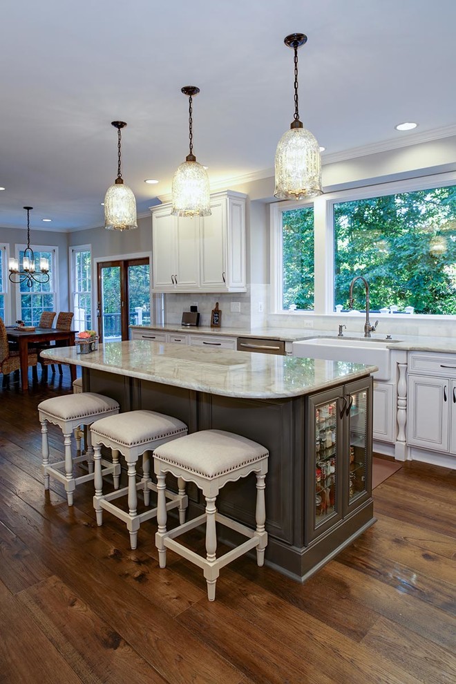 Example of a transitional u-shaped dark wood floor eat-in kitchen design in Cedar Rapids with a farmhouse sink, flat-panel cabinets, white cabinets, marble countertops, stainless steel appliances and an island