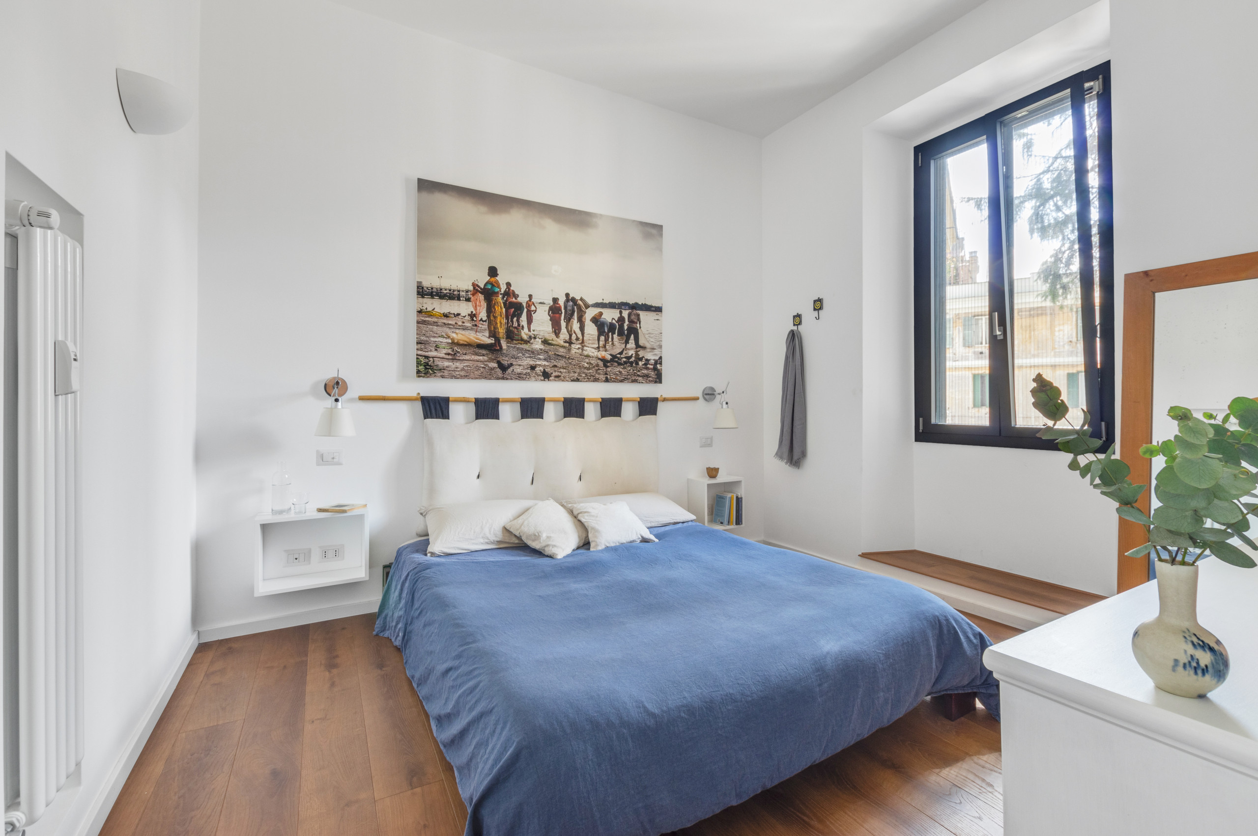 Mid-sized minimalist master dark wood floor and brown floor bedroom photo in Rome with white walls