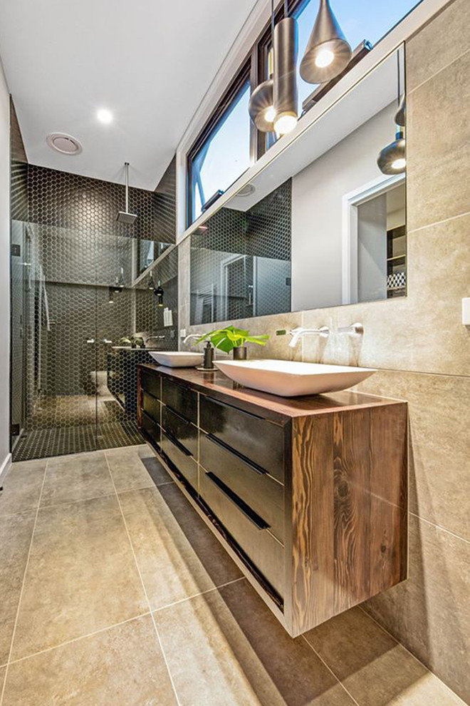 This is an example of a large eclectic master bathroom in Melbourne with flat-panel cabinets, black cabinets, a double shower, beige tile, porcelain tile, beige walls, porcelain floors, a vessel sink, wood benchtops, beige floor, a hinged shower door and brown benchtops.