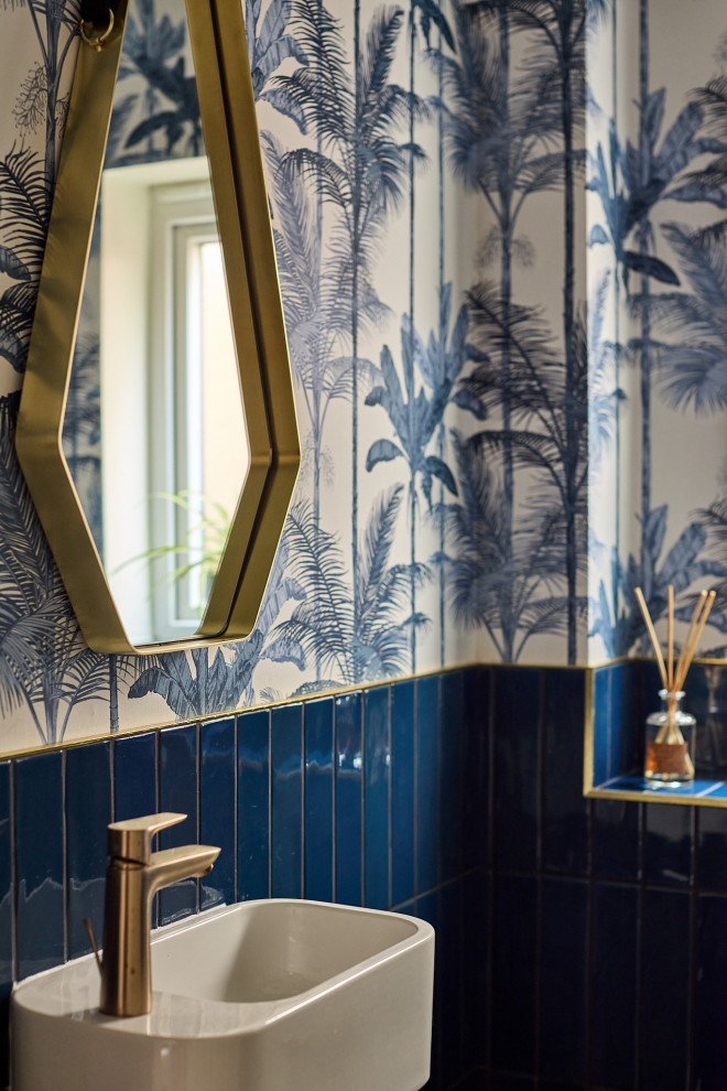 Idee per una piccola stanza da bagno contemporanea con WC monopezzo, piastrelle blu, piastrelle in gres porcellanato, pareti blu, pavimento in gres porcellanato, lavabo sospeso, pavimento nero, toilette, un lavabo e carta da parati