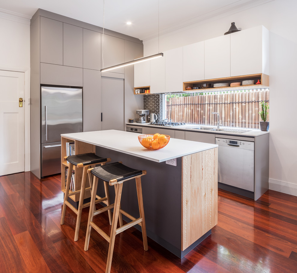 Design ideas for a small modern galley kitchen in Perth with a drop-in sink, flat-panel cabinets, grey cabinets, quartz benchtops, black splashback, ceramic splashback, stainless steel appliances, with island and grey benchtop.