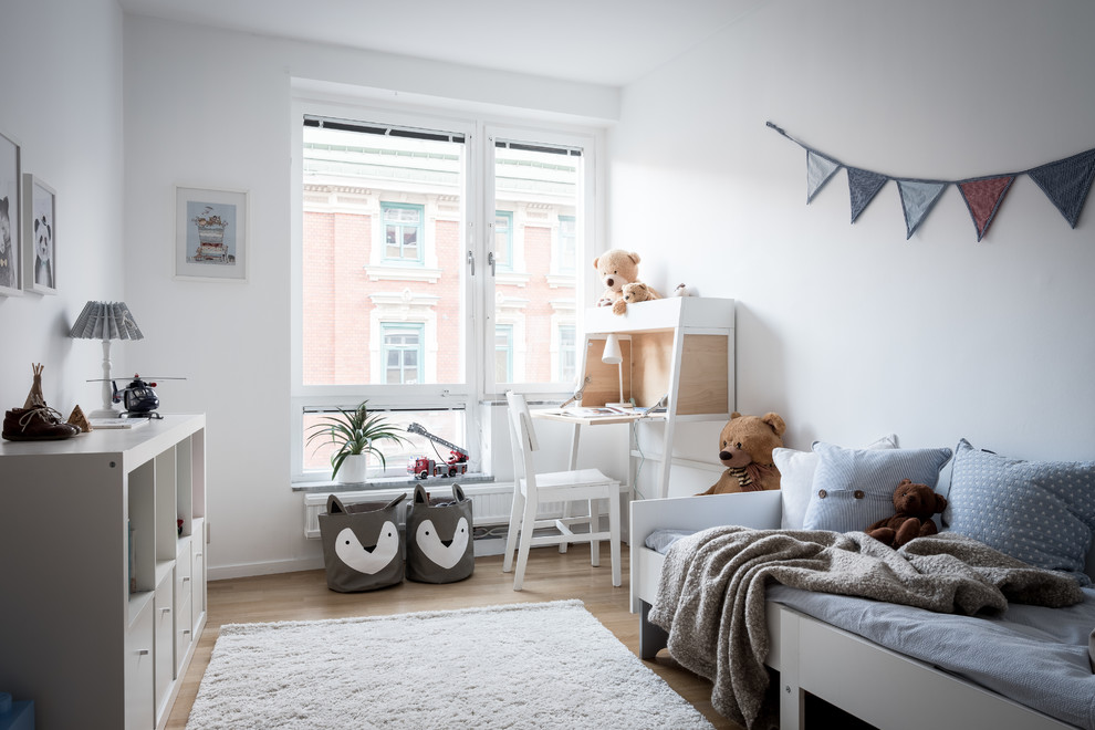 Scandinavian gender-neutral kids' bedroom in Gothenburg with white walls, light hardwood floors and beige floor.