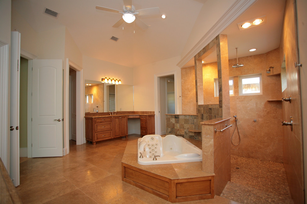 This is an example of an expansive traditional master bathroom in Jacksonville with granite benchtops, a hot tub, an open shower, beige tile, stone slab, marble floors, an undermount sink, furniture-like cabinets, medium wood cabinets, a two-piece toilet and beige walls.