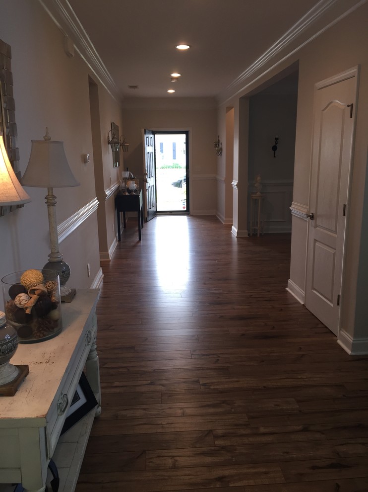 This is an example of a large transitional foyer in Charleston with beige walls, a single front door, a black front door and laminate floors.