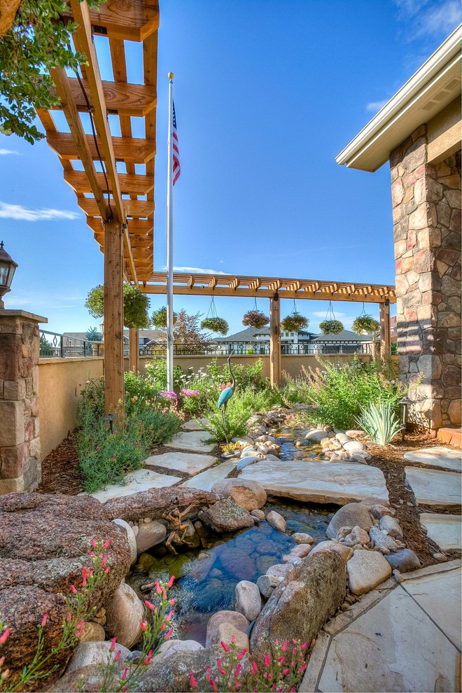 Inspiration for a mid-sized transitional partial sun front yard stone walkway in Denver.