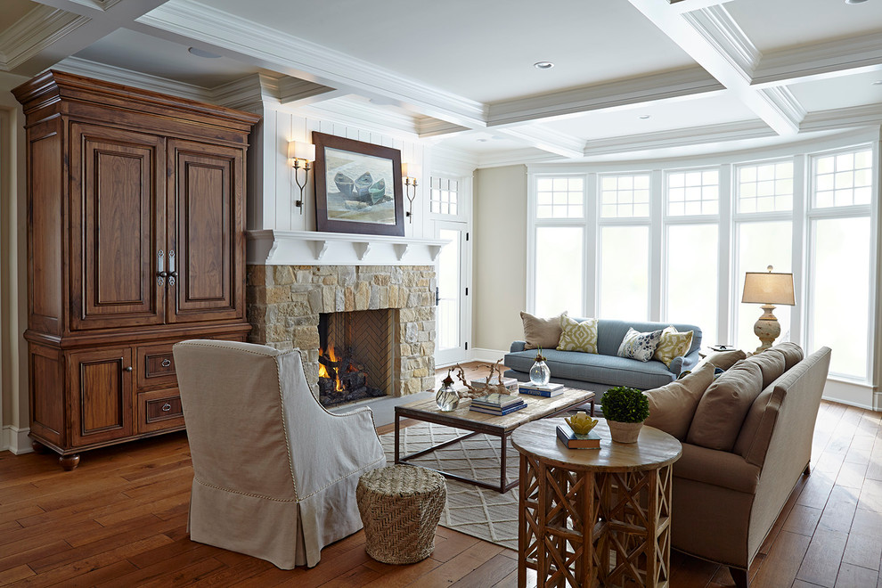 Inspiration for a large beach style open concept living room in Minneapolis with beige walls, a standard fireplace, a stone fireplace surround and a concealed tv.