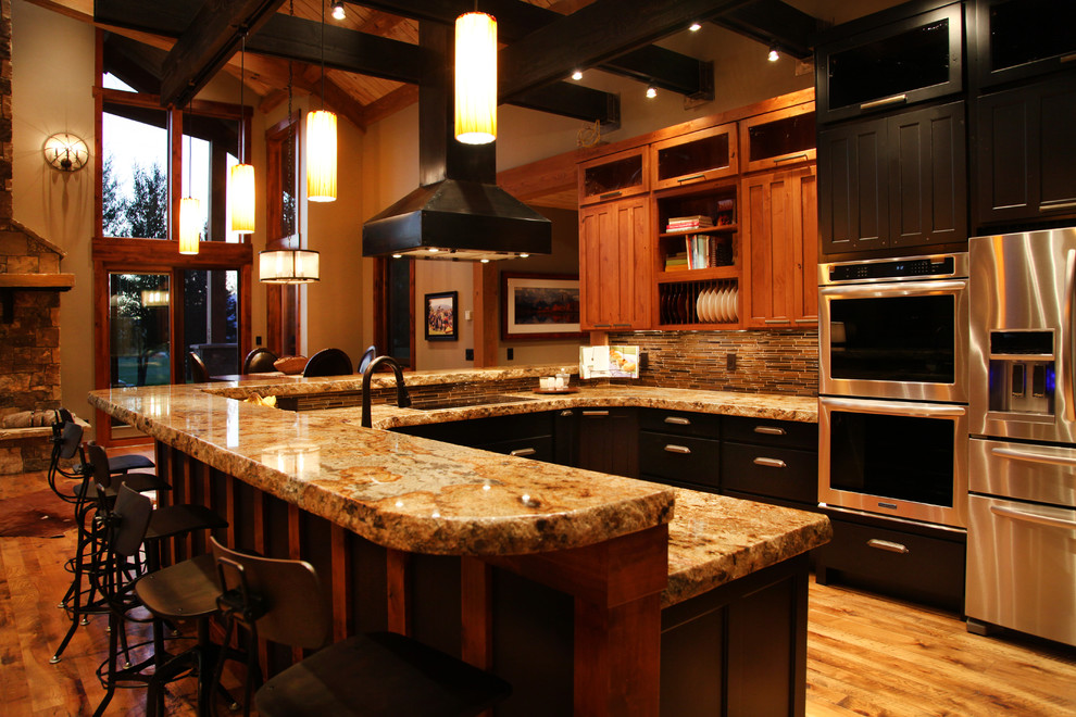 Large mountain style l-shaped light wood floor and beige floor open concept kitchen photo with medium tone wood cabinets, granite countertops, stainless steel appliances, an undermount sink, shaker cabinets, brown backsplash, matchstick tile backsplash and a peninsula