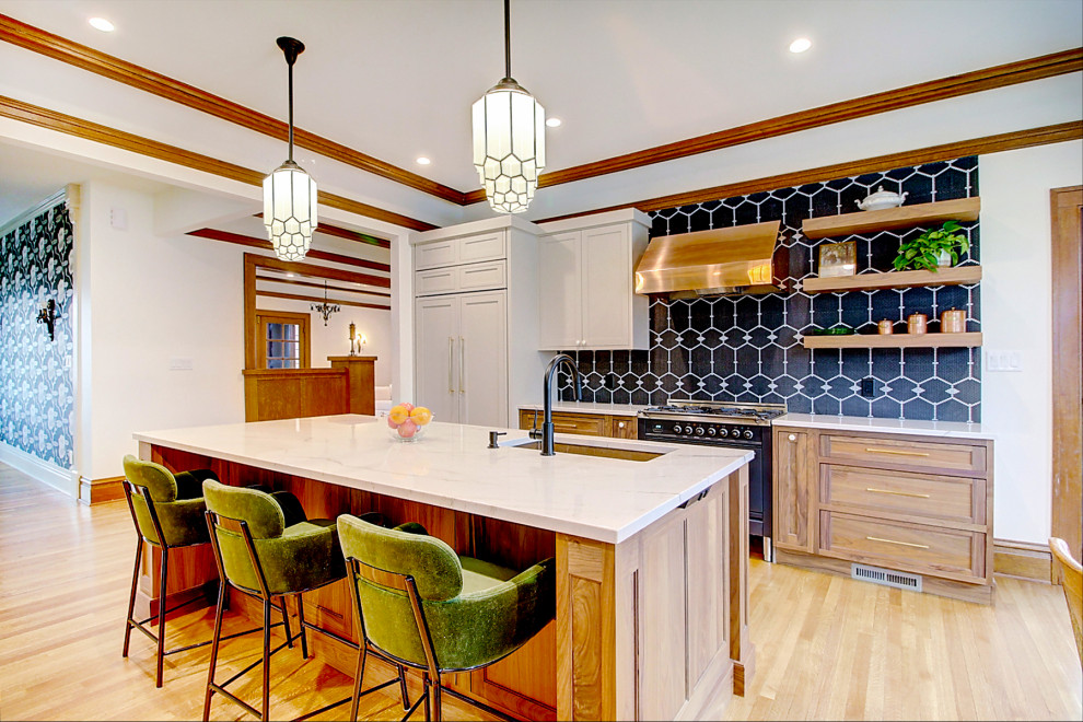 Amerikansk inredning av ett stort vit vitt kök, med en undermonterad diskho, luckor med infälld panel, skåp i mellenmörkt trä, marmorbänkskiva, svart stänkskydd, stänkskydd i mosaik, integrerade vitvaror, ljust trägolv, en köksö och brunt golv