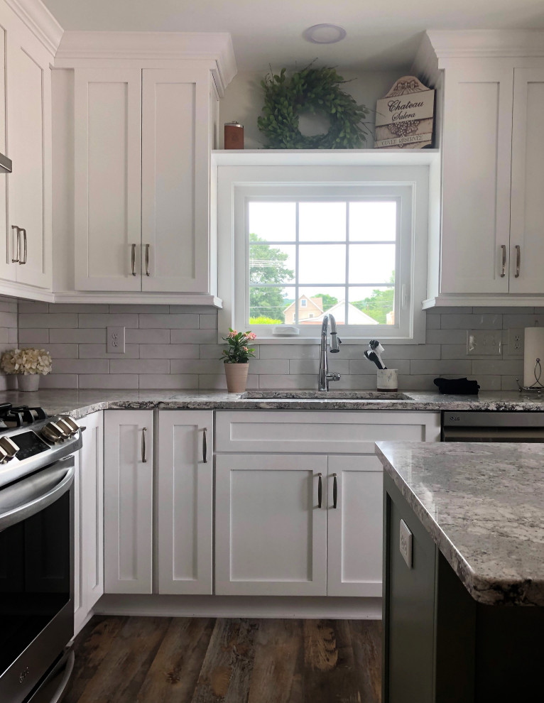 Eat-in kitchen - mid-sized transitional l-shaped vinyl floor and multicolored floor eat-in kitchen idea with an undermount sink, flat-panel cabinets, green cabinets, quartz countertops, white backsplash, ceramic backsplash, stainless steel appliances, an island and gray countertops