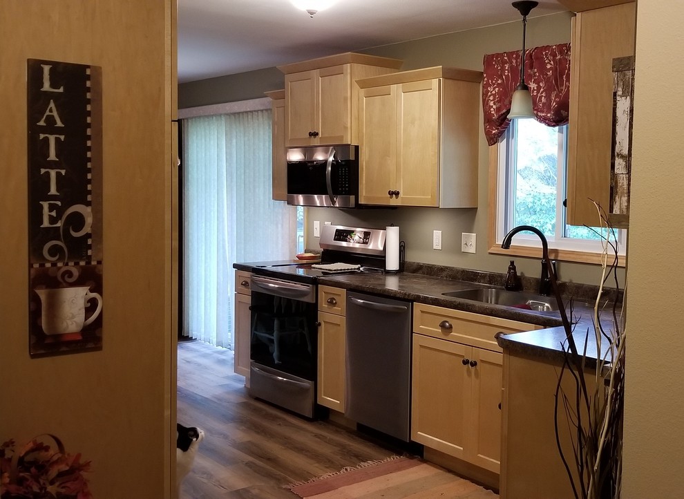 Example of a transitional kitchen design with an undermount sink, shaker cabinets, laminate countertops and no island