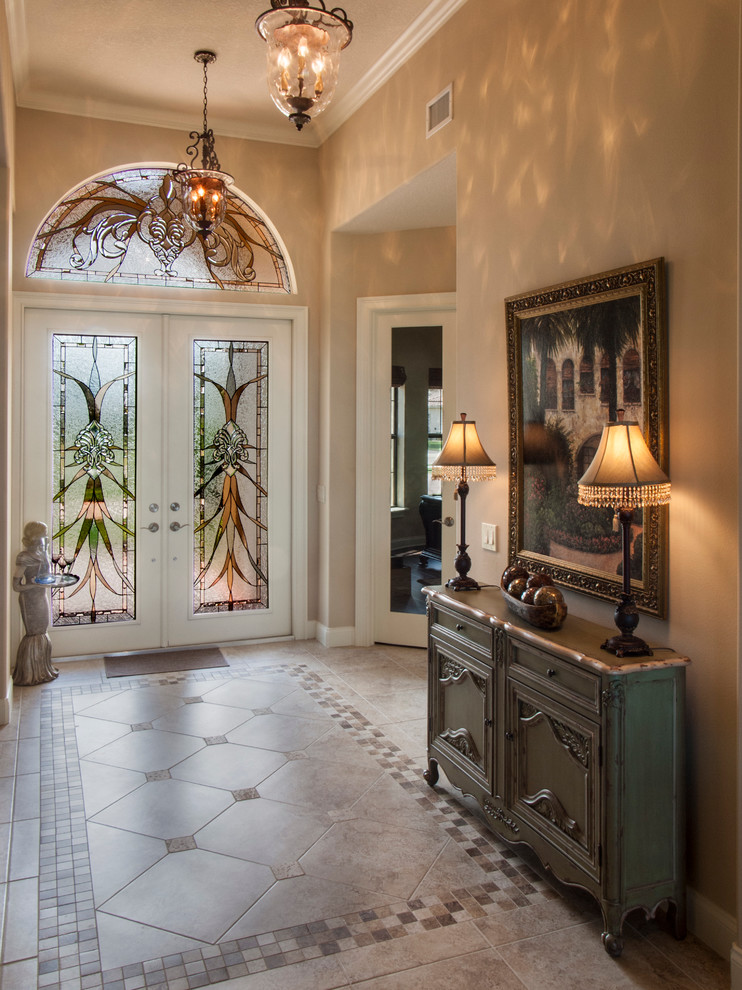 Inspiration for a traditional foyer in Orlando with porcelain floors, a double front door, beige walls and a glass front door.