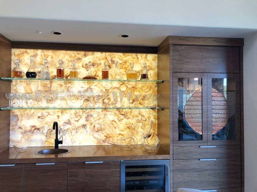 Photo of a mid-sized contemporary single-wall wet bar in Phoenix with a drop-in sink, brown cabinets, wood benchtops, yellow splashback and stone slab splashback.