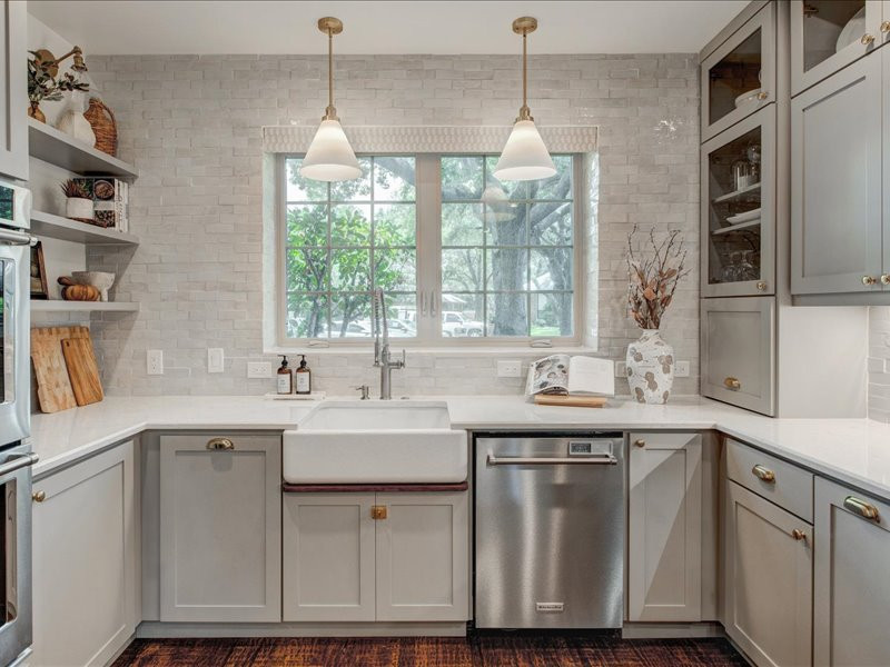 Bild på ett mellanstort, avskilt vintage vit vitt u-kök, med en rustik diskho, skåp i shakerstil, grå skåp, bänkskiva i kvarts, vitt stänkskydd, stänkskydd i cementkakel, rostfria vitvaror, mörkt trägolv, en halv köksö och brunt golv