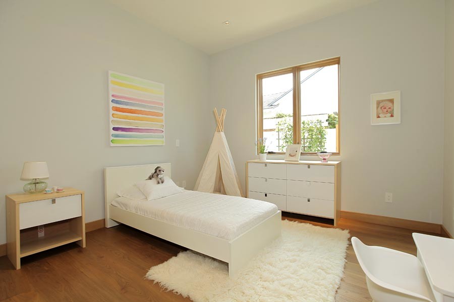 This is an example of a mid-sized midcentury kids' bedroom for kids 4-10 years old and girls in Los Angeles with white walls and medium hardwood floors.