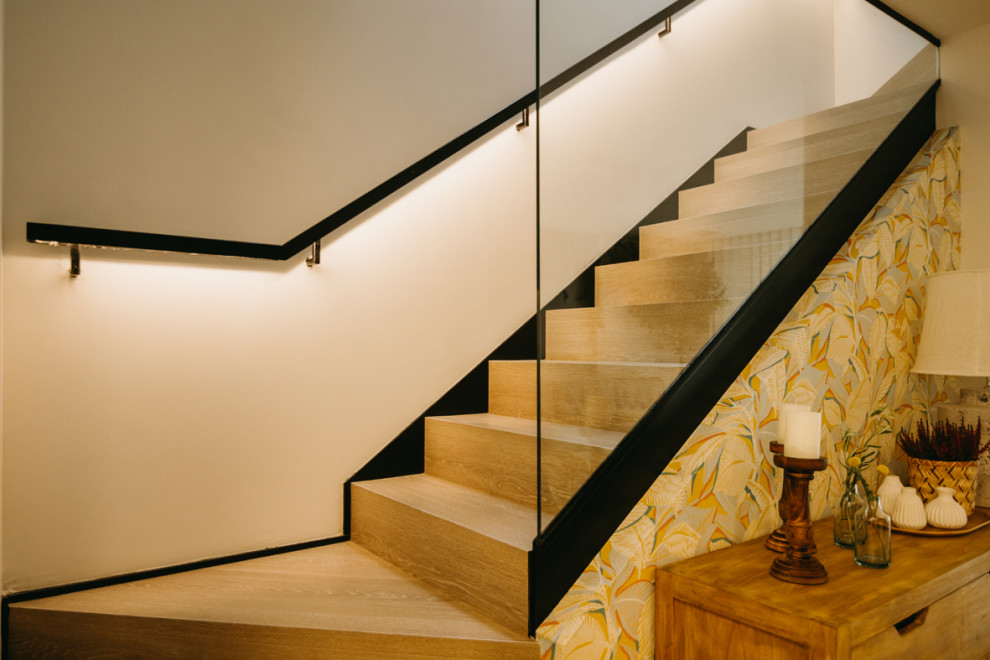 Ejemplo de escalera en U contemporánea de tamaño medio con escalones de madera, contrahuellas de madera, barandilla de metal y papel pintado