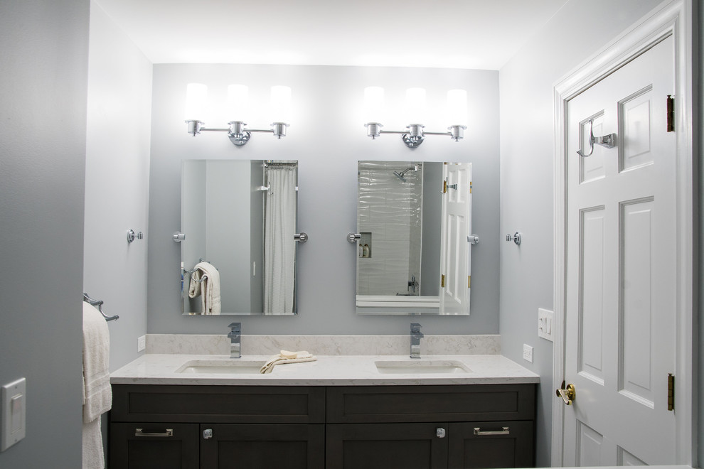 Inspiration for a mid-sized transitional kids bathroom in Chicago with shaker cabinets, grey cabinets, an alcove tub, an alcove shower, a two-piece toilet, white tile, ceramic tile, grey walls, ceramic floors, an undermount sink, engineered quartz benchtops, grey floor, a shower curtain and white benchtops.