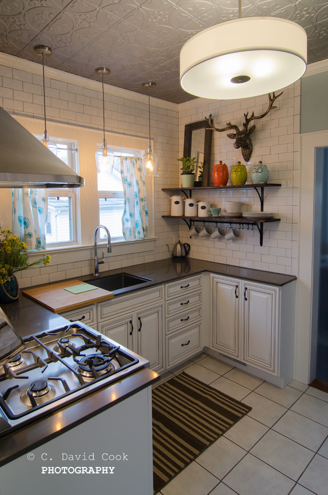 Example of a small transitional u-shaped ceramic tile enclosed kitchen design with an undermount sink, raised-panel cabinets, white cabinets, solid surface countertops, white backsplash, subway tile backsplash, stainless steel appliances and no island