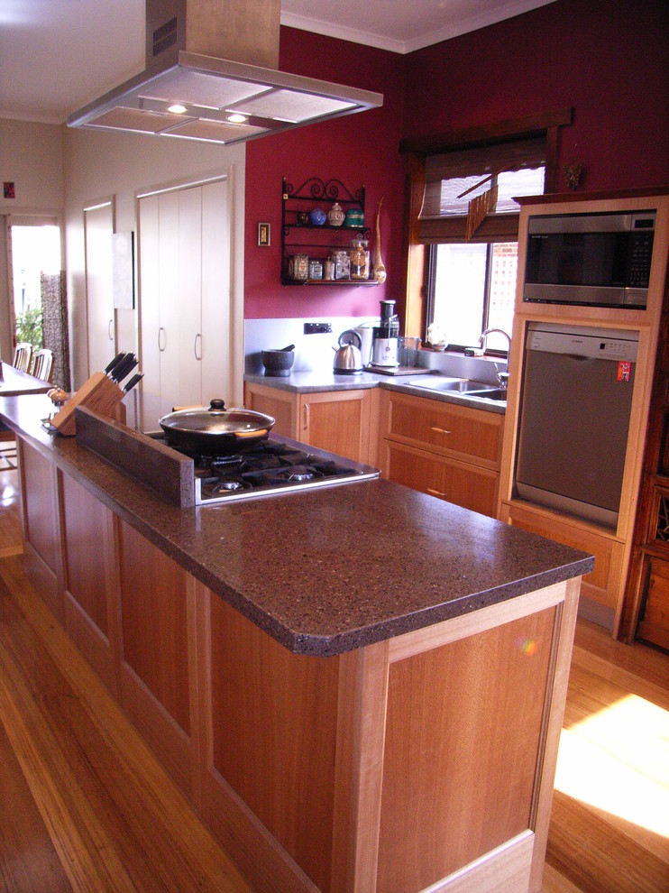 Mid-sized contemporary galley eat-in kitchen in Melbourne with a drop-in sink, shaker cabinets, light wood cabinets, quartz benchtops, red splashback, glass sheet splashback, coloured appliances, light hardwood floors and with island.