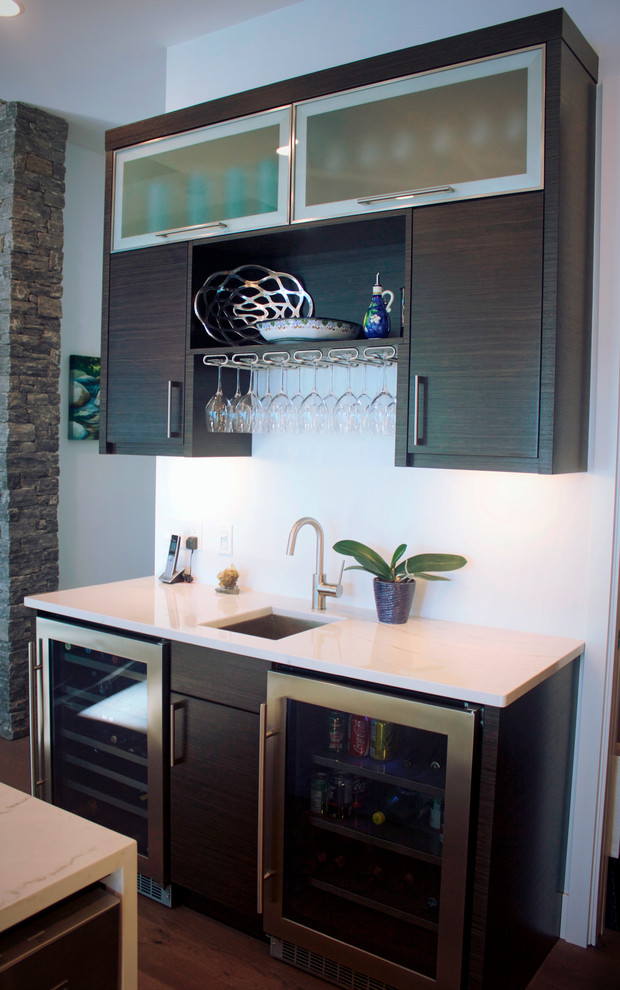 This is an example of a modern l-shaped eat-in kitchen in Other with a farmhouse sink, flat-panel cabinets, dark wood cabinets, stainless steel appliances, with island and white benchtop.