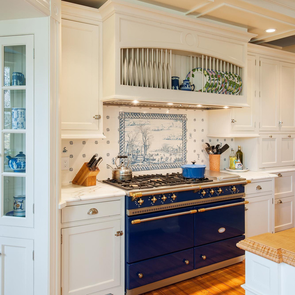 Mid-sized traditional open plan kitchen in Boston with a farmhouse sink, beaded inset cabinets, white cabinets, marble benchtops, white splashback, ceramic splashback, panelled appliances, light hardwood floors and with island.