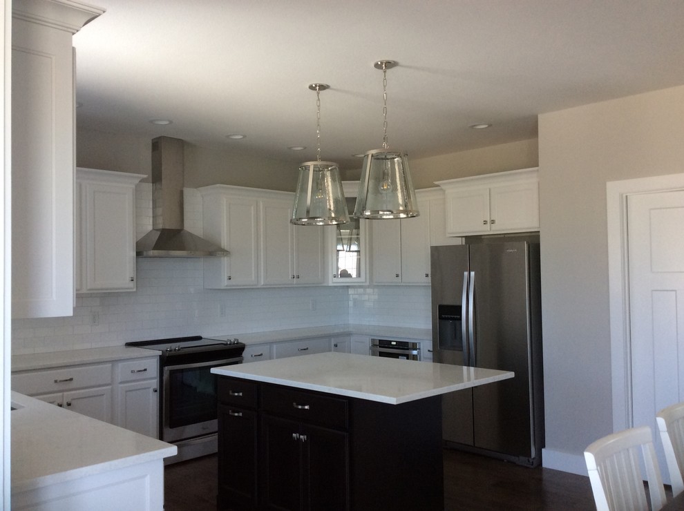 Eat-in kitchen - mid-sized transitional u-shaped dark wood floor eat-in kitchen idea in Chicago with an undermount sink, shaker cabinets, white cabinets, quartz countertops, white backsplash, subway tile backsplash, stainless steel appliances and an island