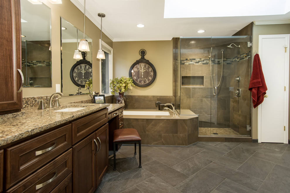 This is an example of a mid-sized traditional master bathroom in Seattle with recessed-panel cabinets, dark wood cabinets, a corner tub, a corner shower, brown walls, porcelain floors, an undermount sink and granite benchtops.
