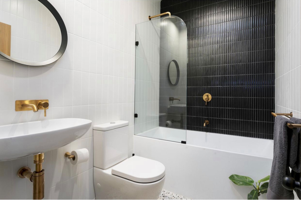 На фото: детская ванная комната среднего размера в стиле модернизм с серыми фасадами, отдельно стоящей ванной, открытым душем, унитазом-моноблоком, черно-белой плиткой, керамической плиткой, белыми стенами, полом из известняка, разноцветным полом, открытым душем, тумбой под одну раковину и встроенной тумбой с
