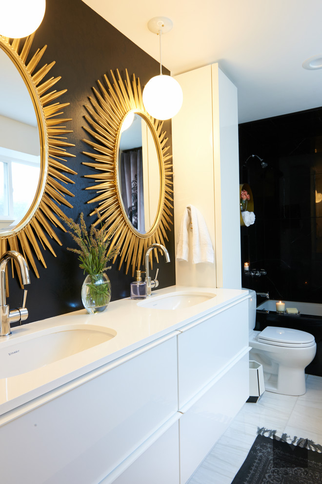 Inspiration for a mid-sized contemporary master bathroom in Salt Lake City with flat-panel cabinets, white cabinets, an undermount tub, a shower/bathtub combo, a two-piece toilet, black and white tile, stone tile, white walls, marble floors, an undermount sink and engineered quartz benchtops.