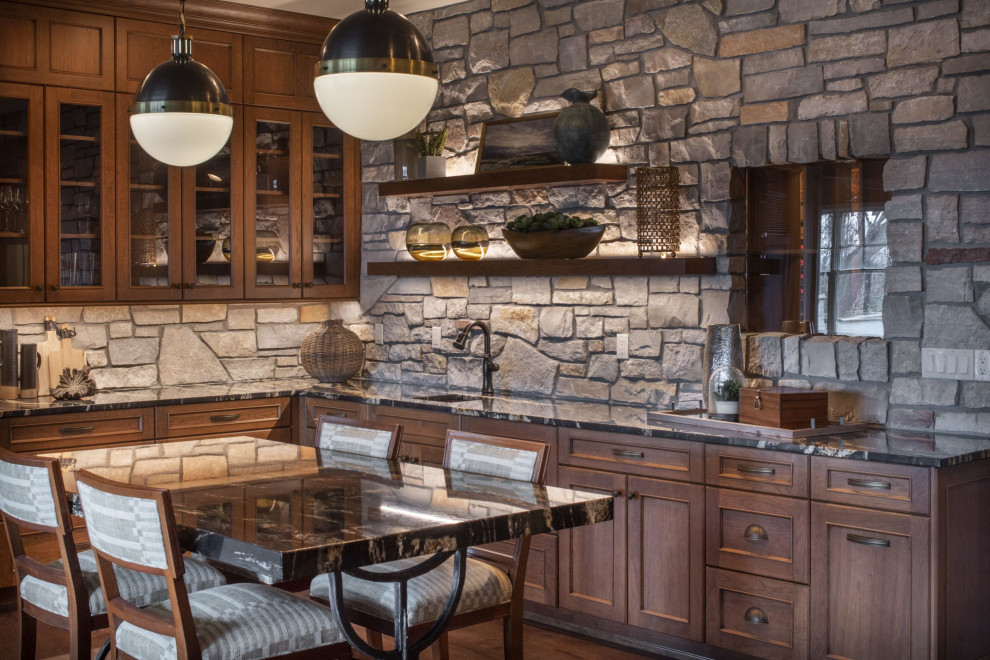 Inspiration for a mid-sized transitional l-shaped wet bar in Minneapolis with an undermount sink, glass-front cabinets, dark wood cabinets, marble benchtops, grey splashback, dark hardwood floors, brown floor and black benchtop.