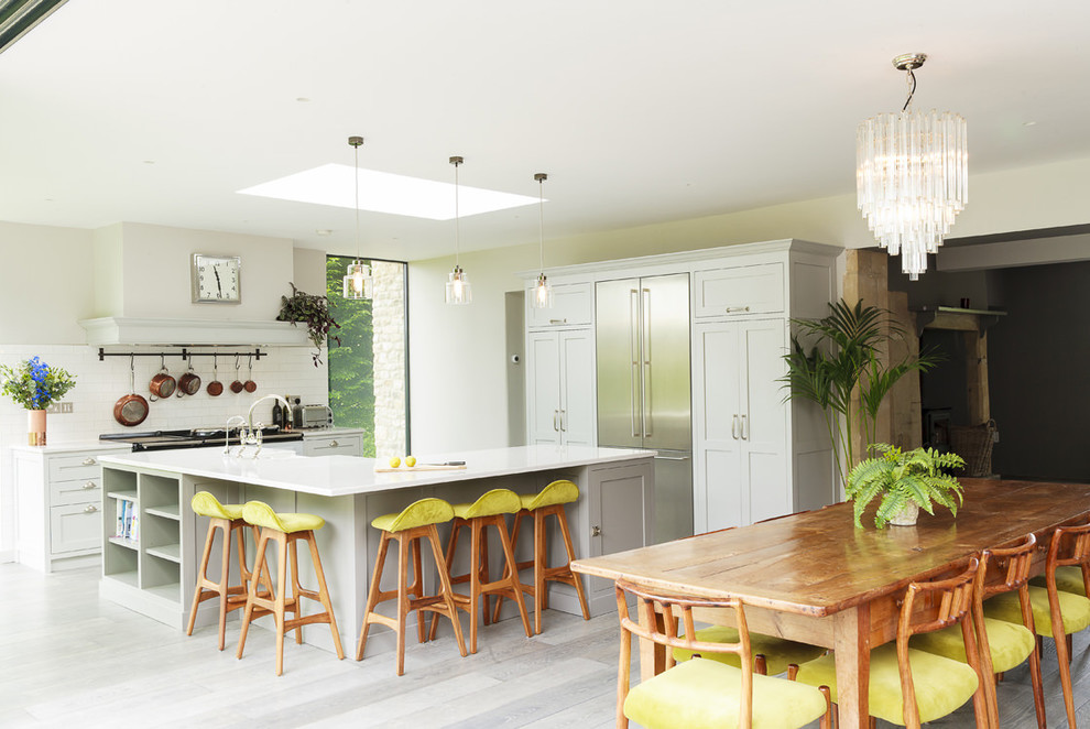 Design ideas for a large transitional open plan kitchen in Other with a farmhouse sink, shaker cabinets, solid surface benchtops, white splashback, subway tile splashback and with island.