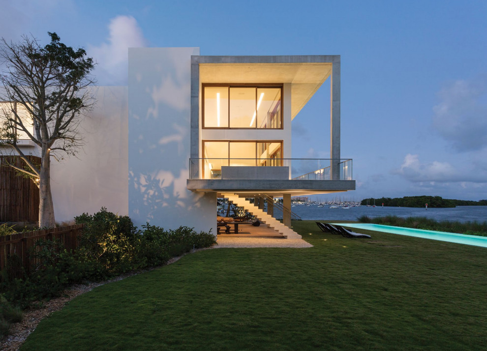 This is an example of an expansive contemporary three-storey concrete white exterior in Miami.