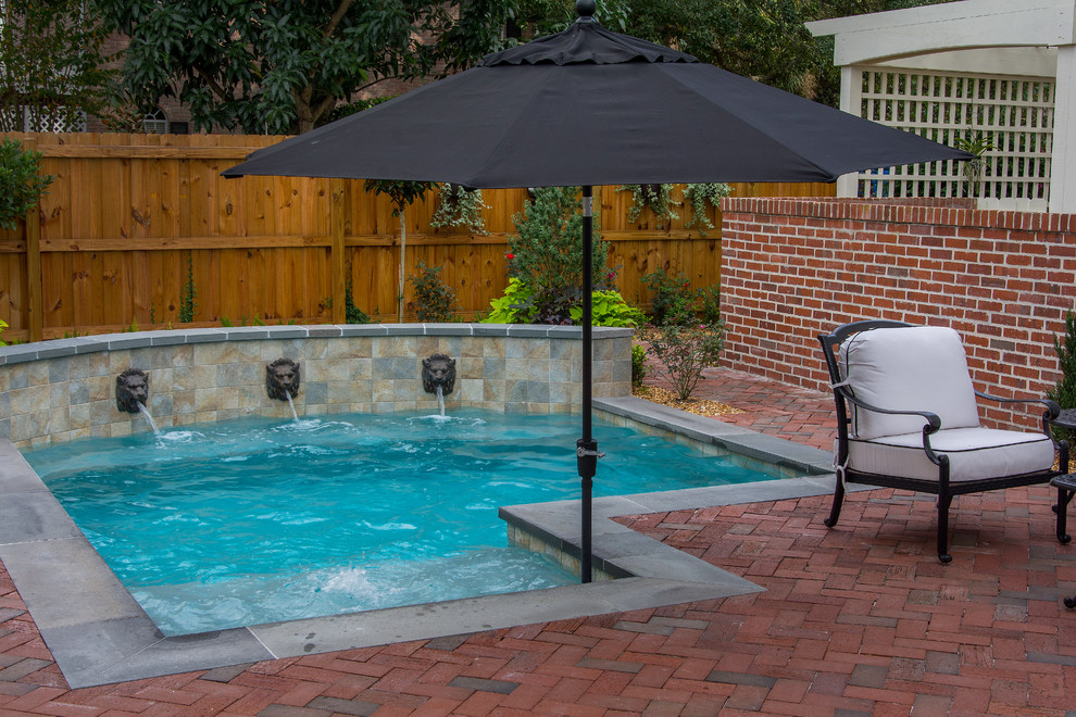 Design ideas for a small traditional backyard custom-shaped natural pool in Tampa with a hot tub and brick pavers.