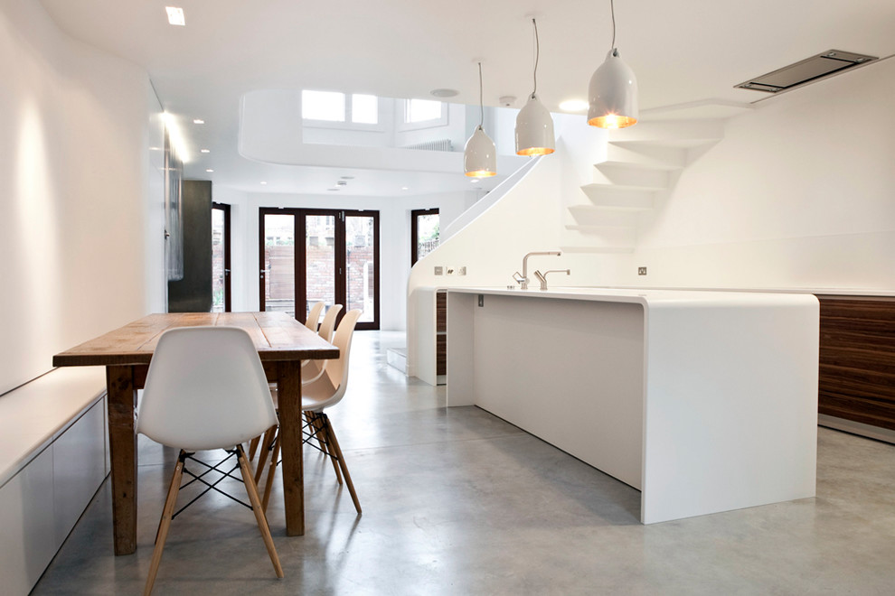 Photo of a small modern galley eat-in kitchen in London with solid surface benchtops, white splashback, concrete floors, with island, grey floor and white benchtop.