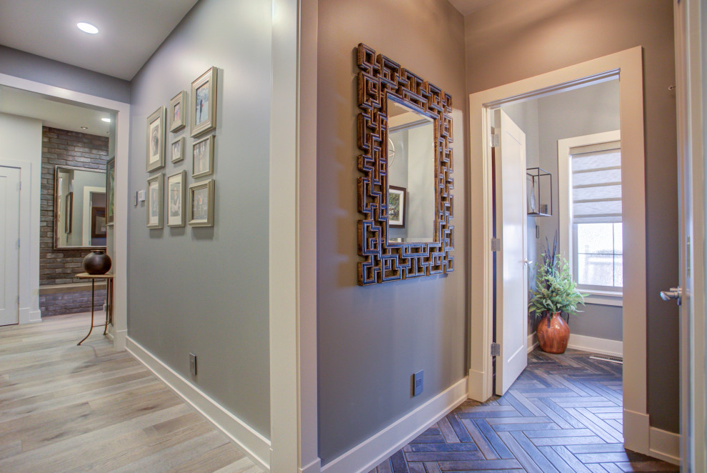 Large contemporary hallway in Calgary with grey walls, light hardwood floors and brown floor.