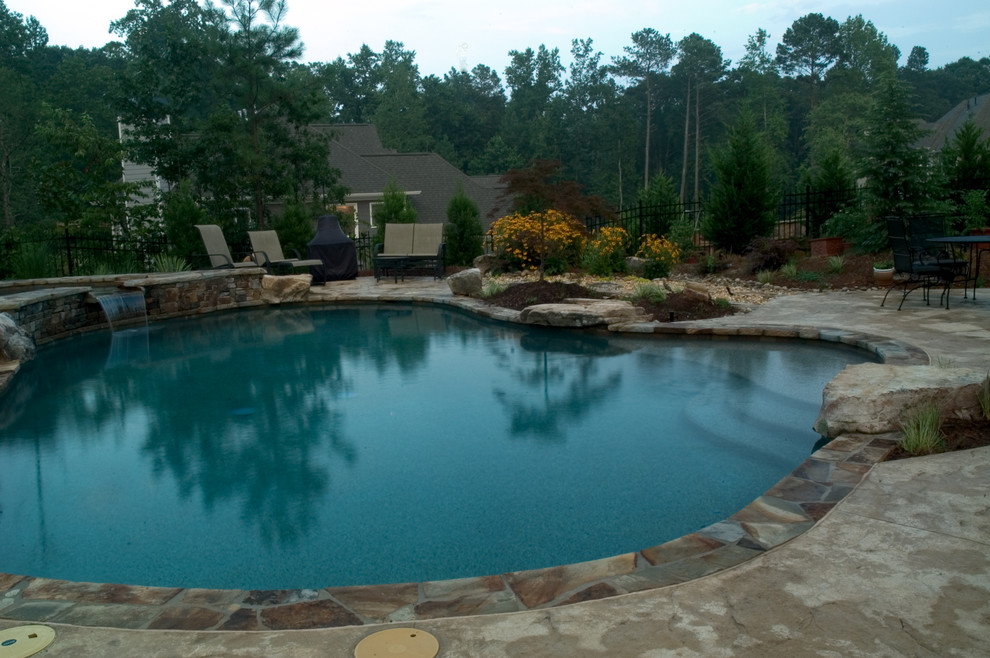Inspiration for a mid-sized rustic backyard stone and kidney-shaped hot tub remodel in Atlanta