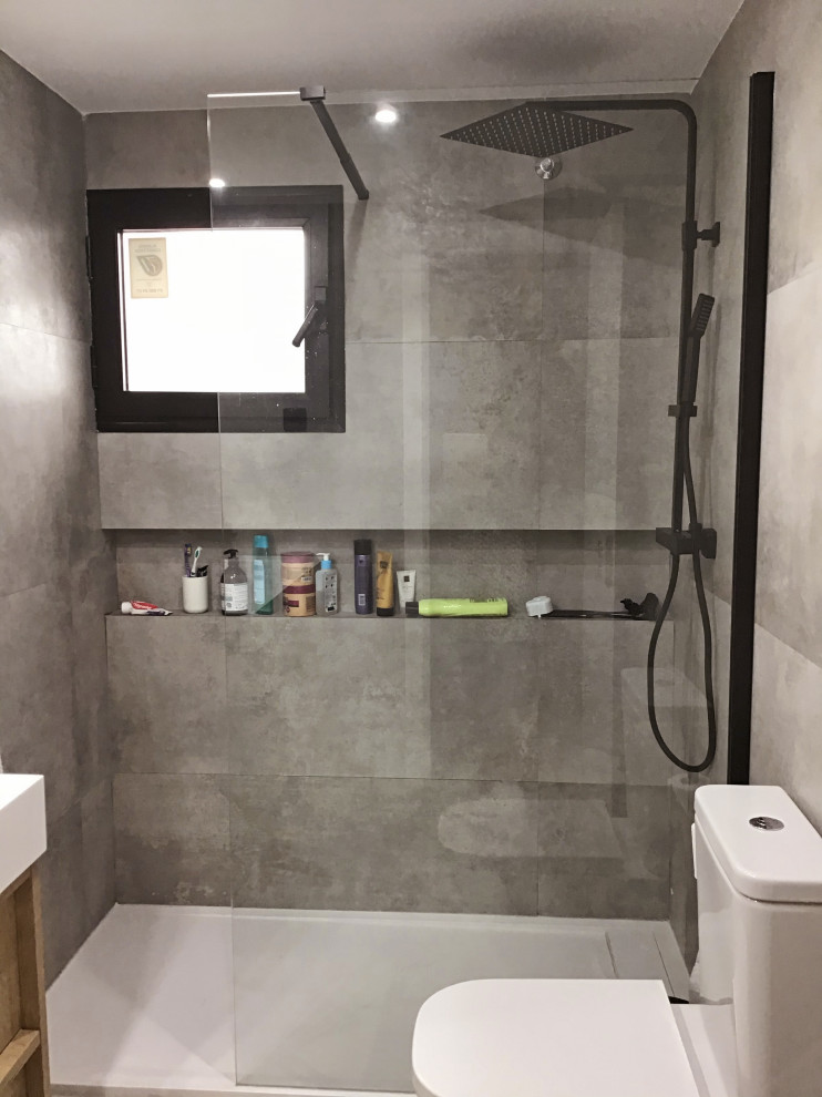 Medium sized contemporary grey and white bathroom in Madrid with white cabinets, a built-in shower, a two-piece toilet, grey tiles, grey walls, an integrated sink, solid surface worktops, brown floors, an open shower, white worktops, an enclosed toilet, a single sink and a built in vanity unit.