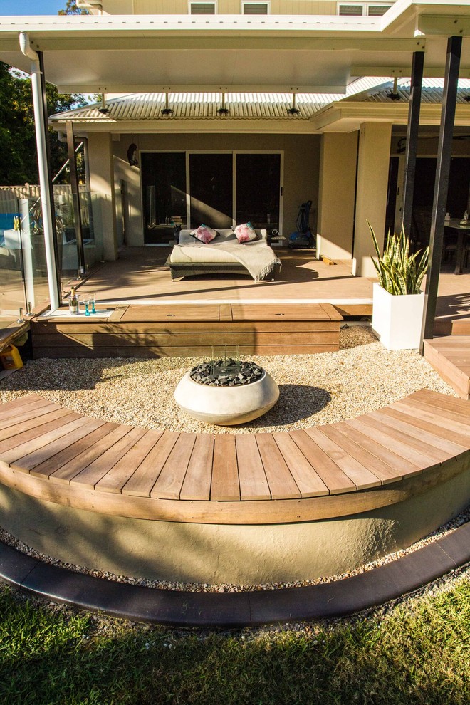 Photo of a contemporary backyard partial sun formal garden in Brisbane with a fire feature and gravel.
