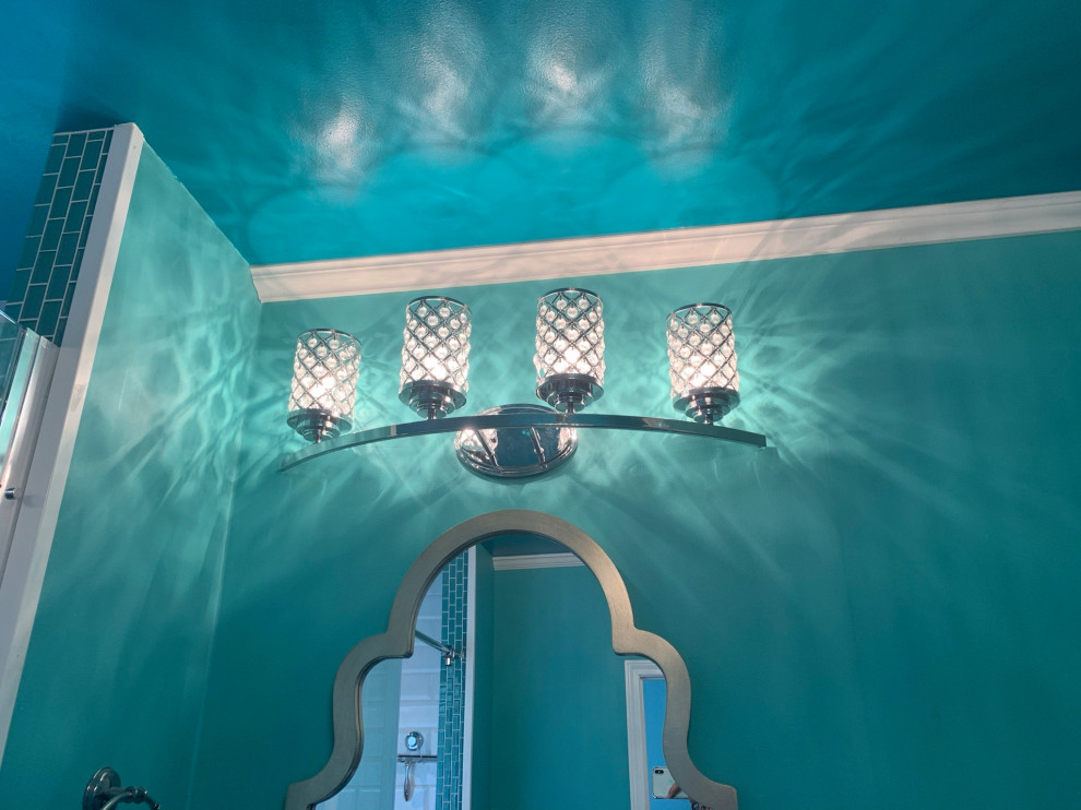 На фото: большая главная ванная комната в стиле фьюжн с фасадами с утопленной филенкой, белыми фасадами, отдельно стоящей ванной, душем над ванной, раздельным унитазом, зеленой плиткой, плиткой из листового стекла, зелеными стенами, паркетным полом среднего тона, монолитной раковиной, столешницей из гранита, коричневым полом, душем с раздвижными дверями, серой столешницей, тумбой под одну раковину и напольной тумбой