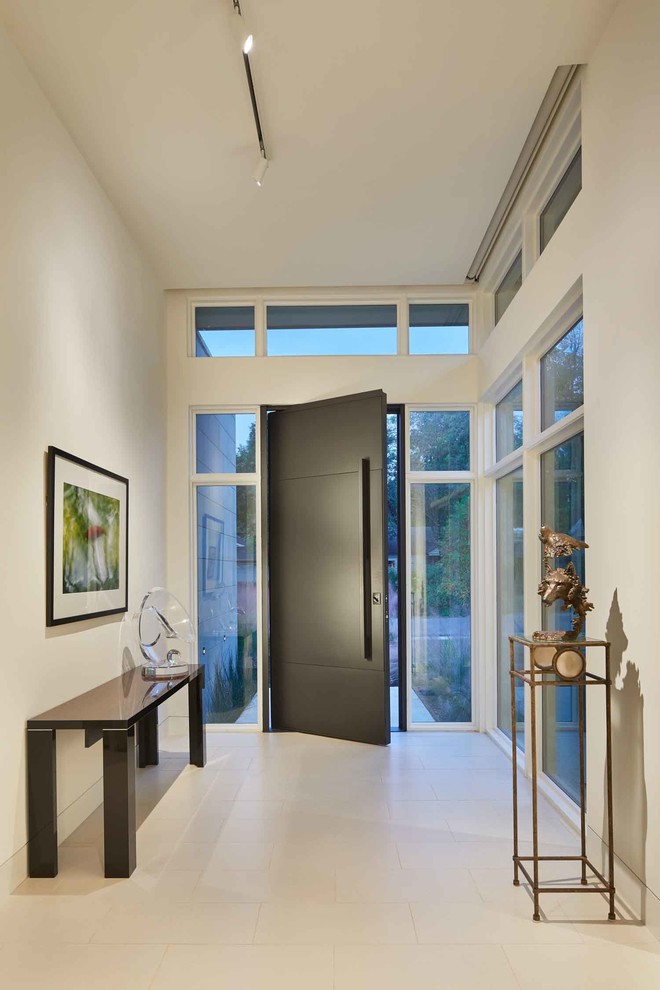 Inspiration for a large modern front door in Dallas with white walls, limestone floors, a pivot front door, a black front door and white floor.
